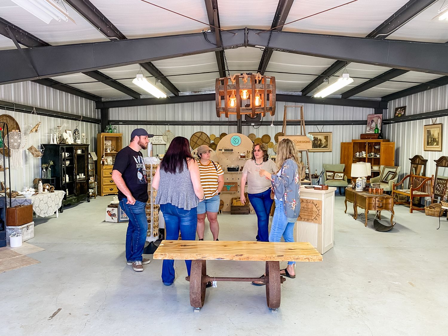 Rustic retail space interior with wooden beams and vintage furniture displays.