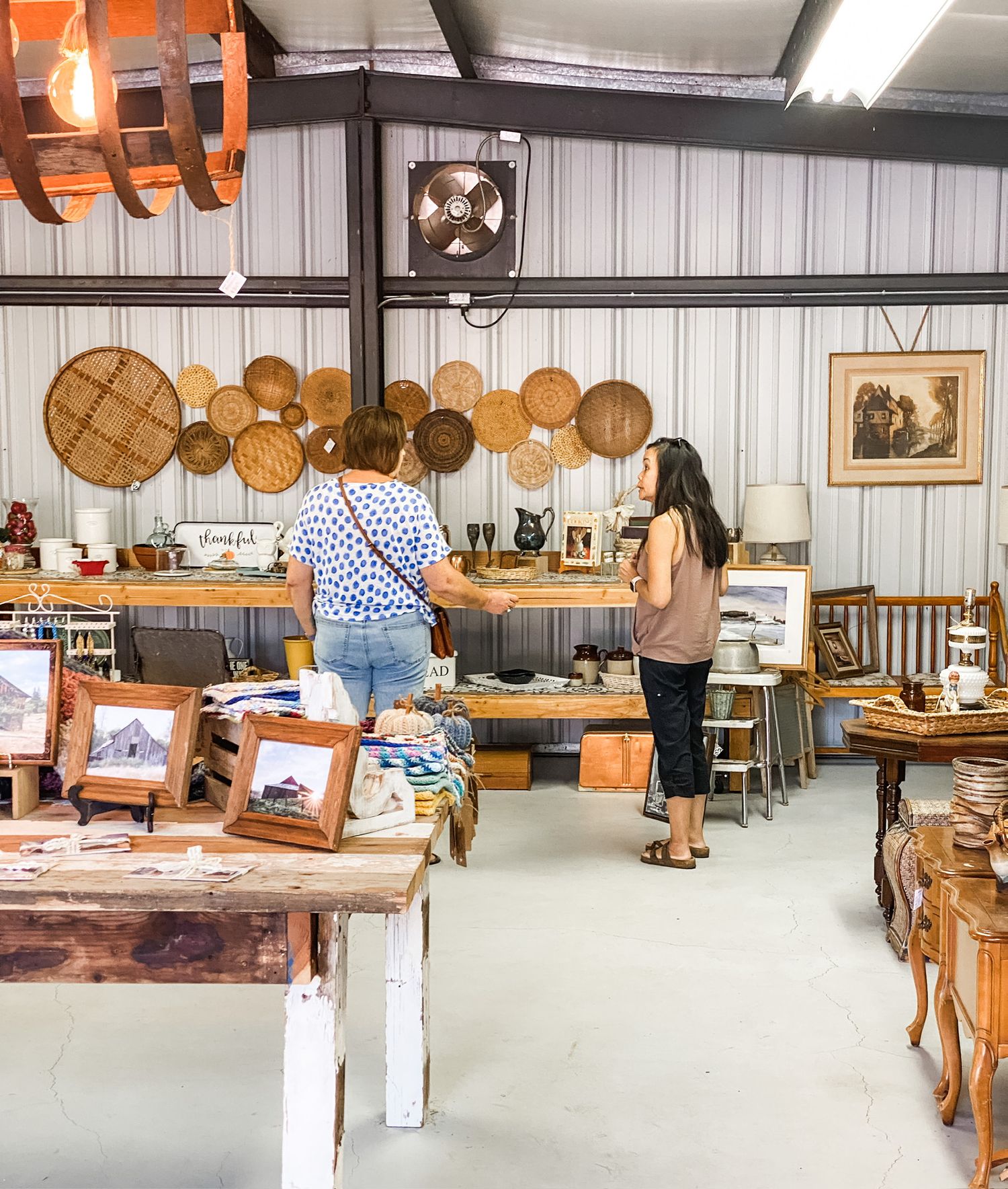 Rustic antique store interior with wooden wall displays and vintage bread boards.