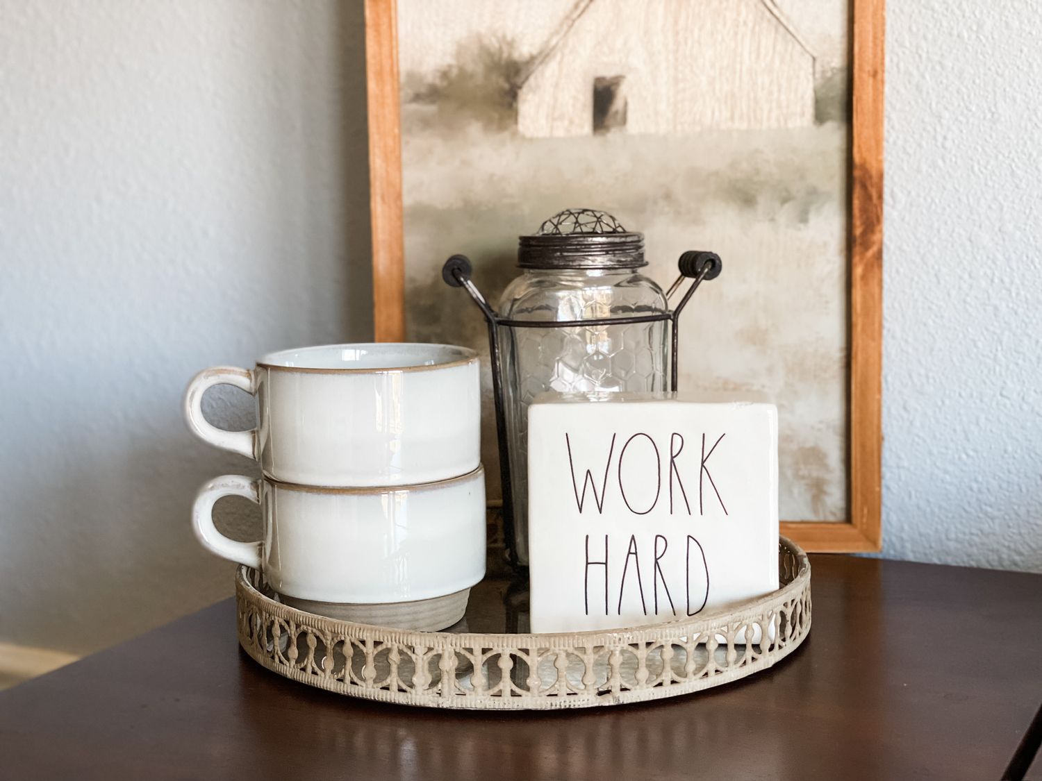 Vintage coffee setup with white mugs and 'work hard' sign on decorative tray.
