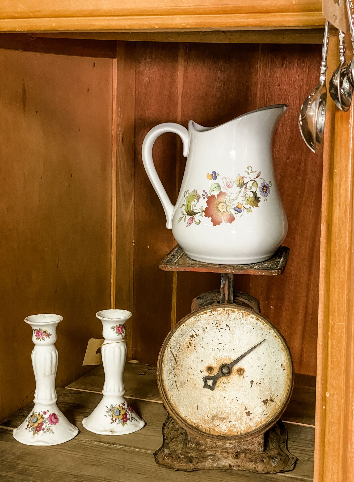 Antique wooden table with ornate details and brown glass bottles displayed between matching mirrors.