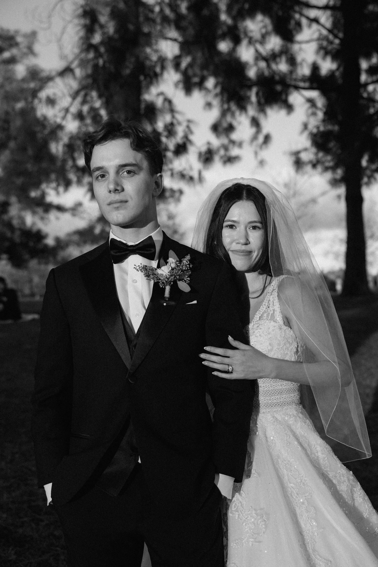 A romantic black and white wedding photoshoot series showing tender moments between the newlyweds in an outdoor setting.