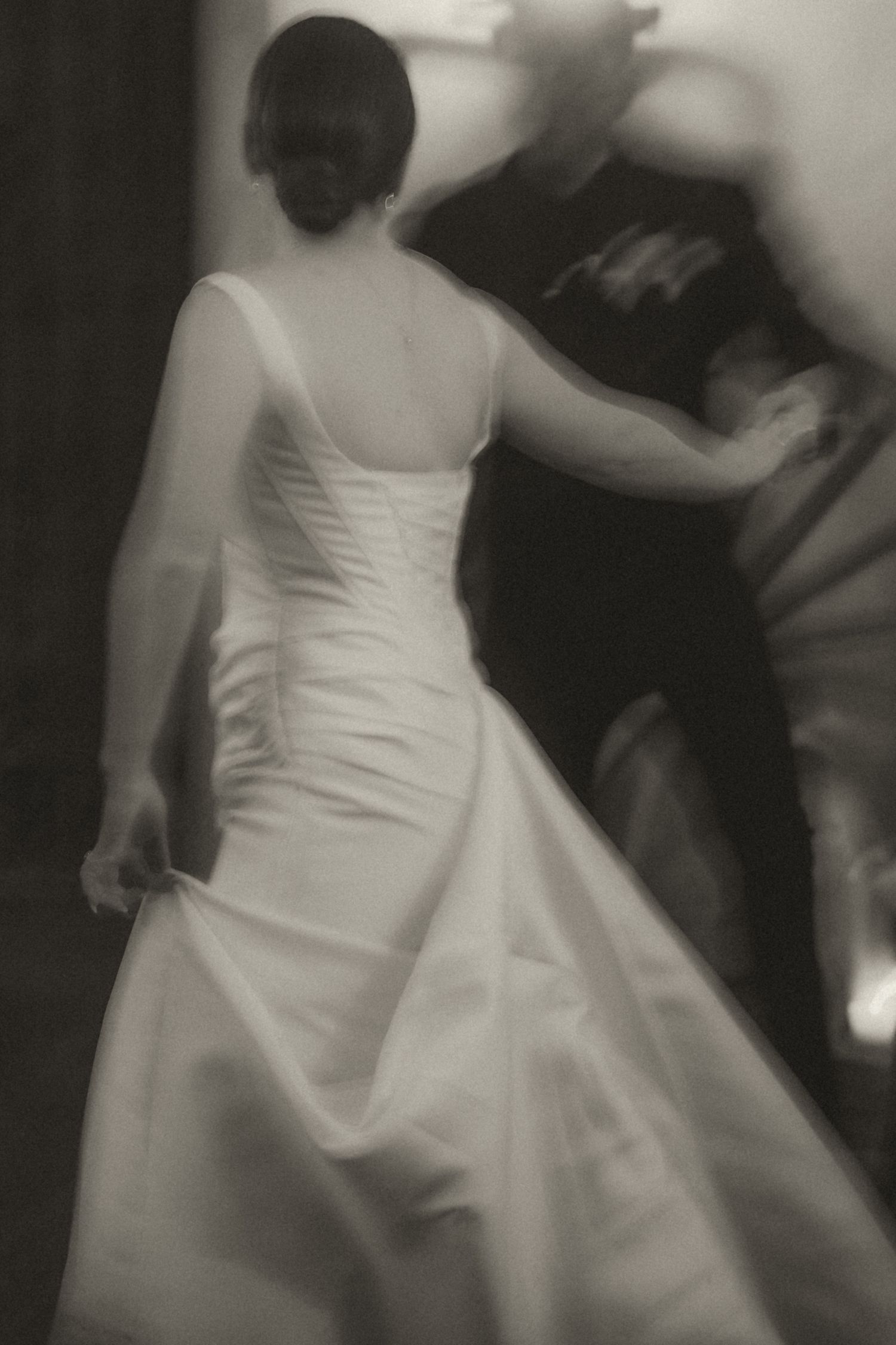 A series of black and white photos showing a bride in a white wedding dress dancing and twirling on the dance floor.