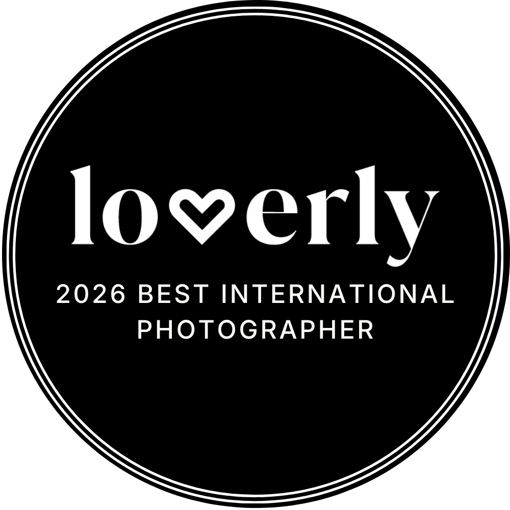 Black circular badge reading Loverly 2026 Best International Photographer award logo with heart detail.