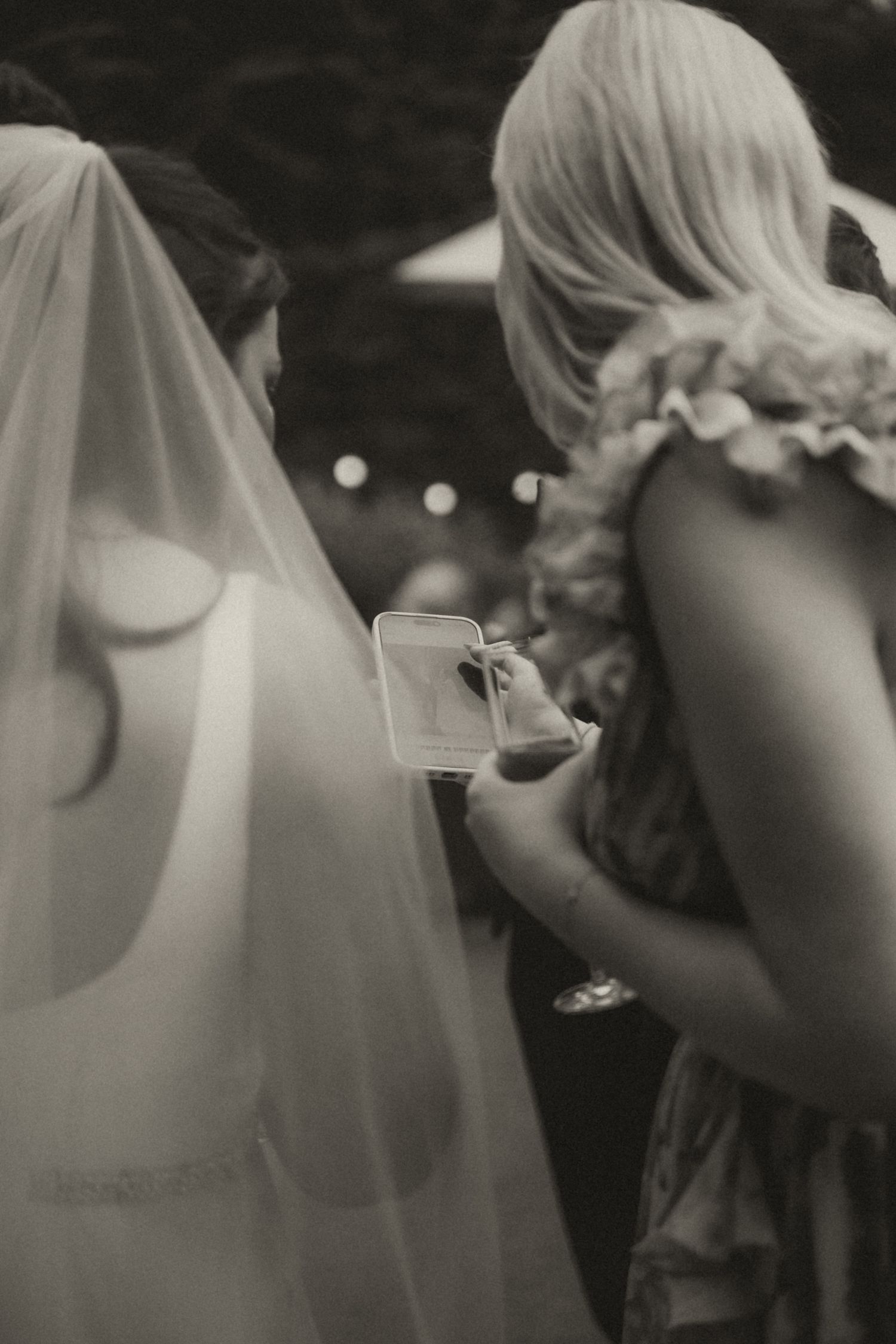 Black and white wedding photo series showing bride and bridesmaids in veils and dresses preparing for ceremony.