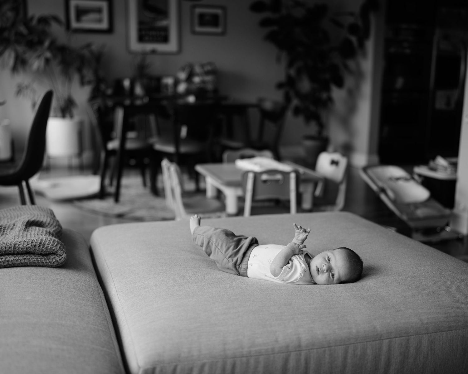 A black and white photo series showing a sleeping baby on a couch in different positions and angles.