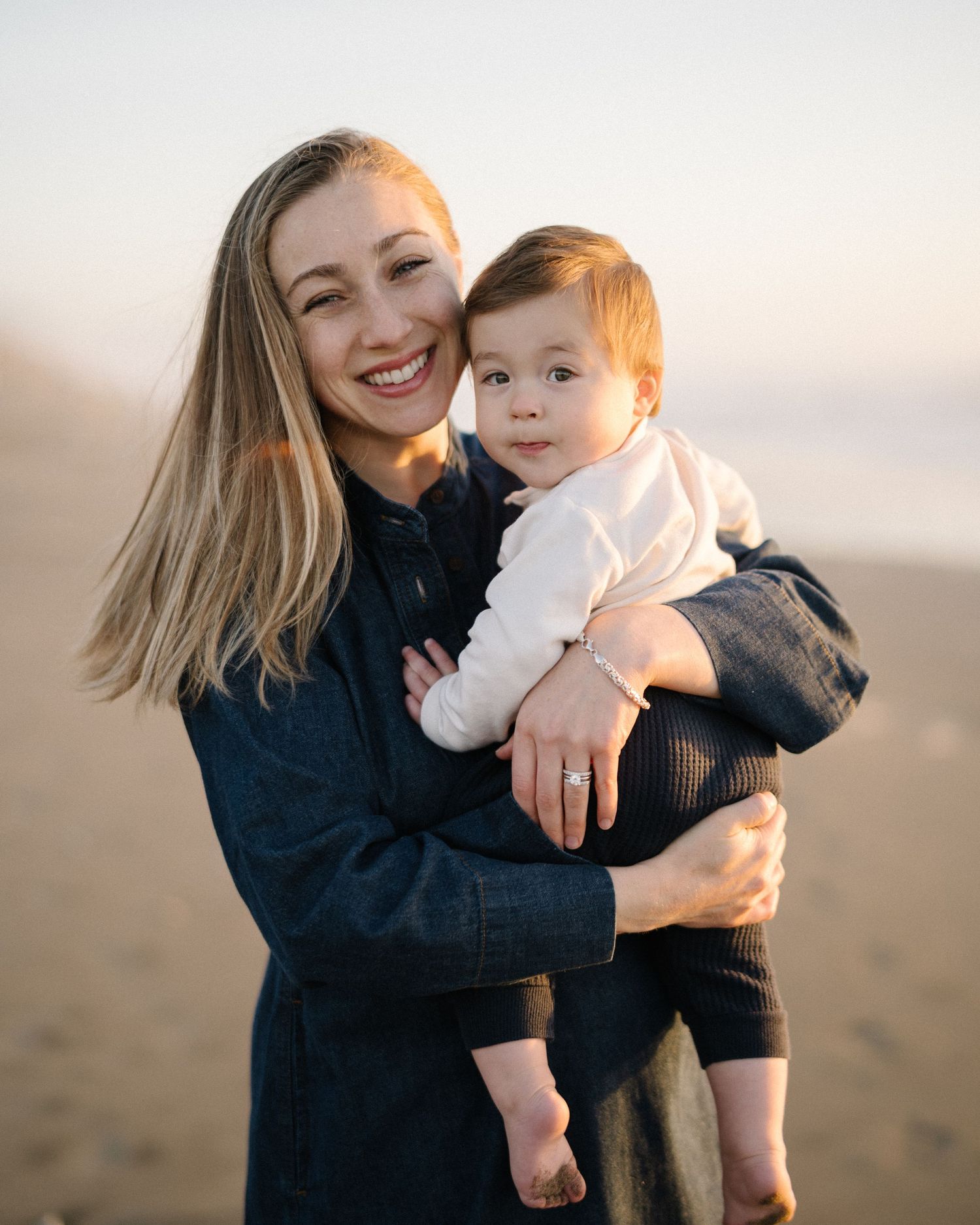Parent and child share tender moments together on a beach at sunset in a series of heartwarming candid photos.