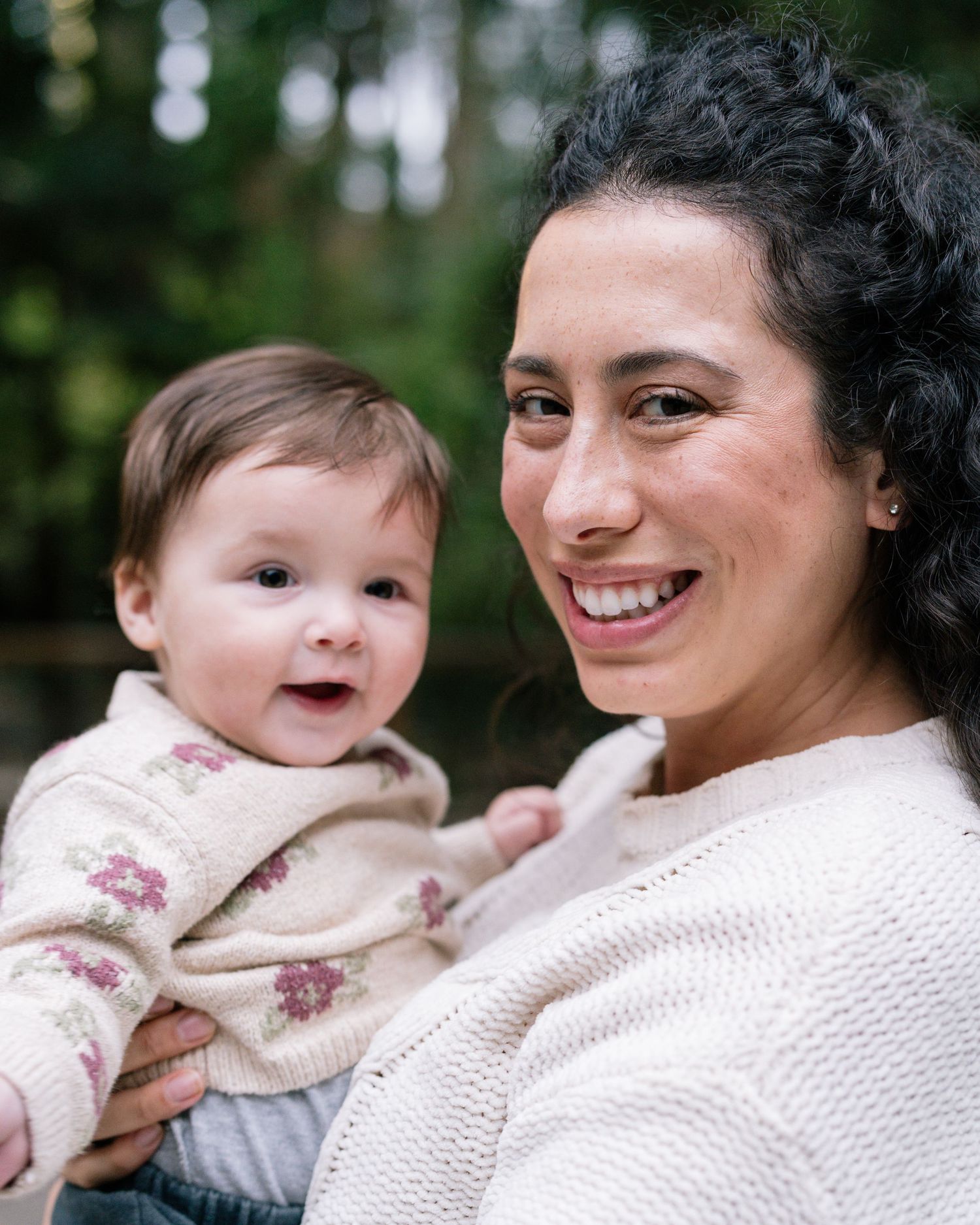 A heartwarming series of candid moments between parent and baby sharing smiles and cuddles in an outdoor setting.