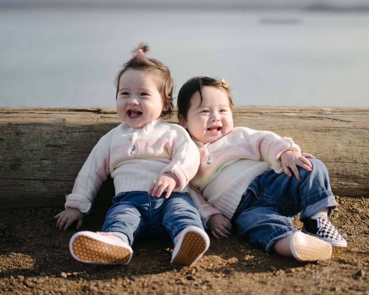 A series of candid photos showing two young children lying on the ground together laughing and playing.