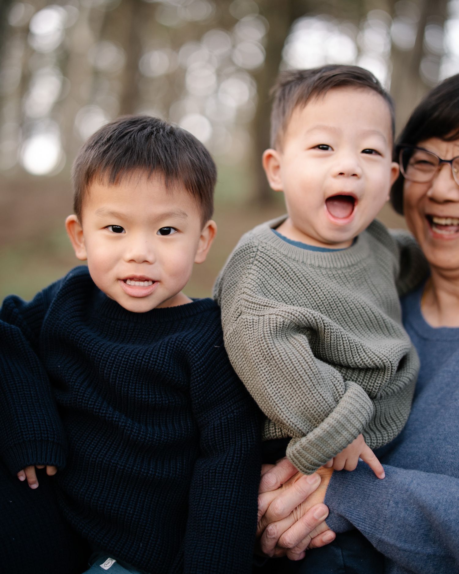 A joyful family moment captured outdoors with warm sweaters and genuine expressions of happiness.