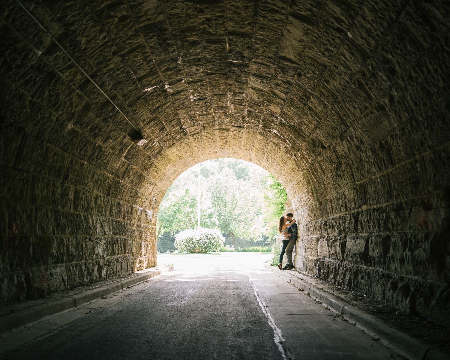 A sequence of photos showing a person walking through a long stone tunnel with light visible at the end.