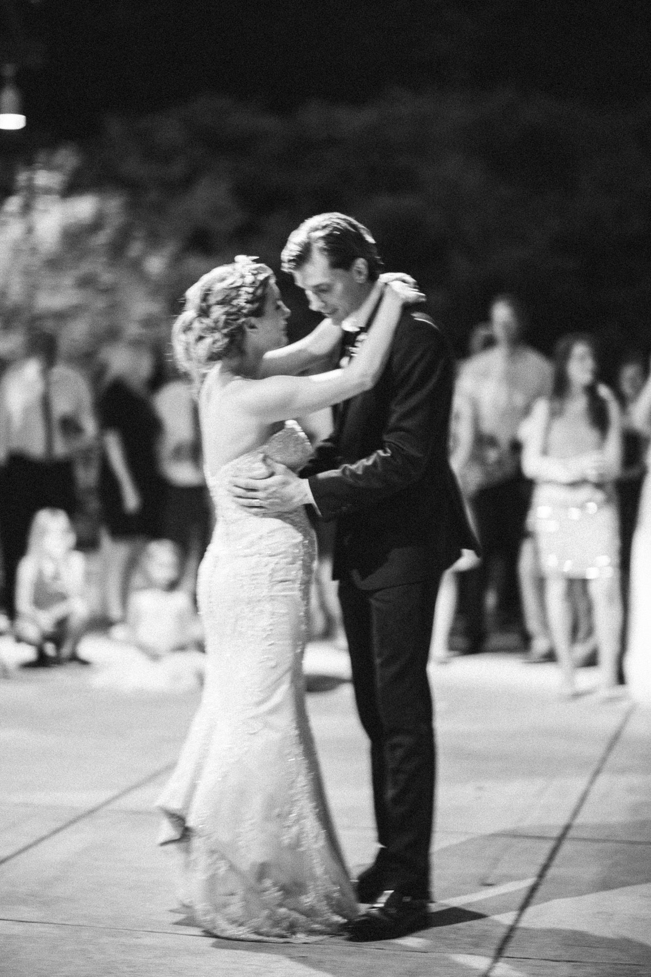 A series of black and white photos showing a couple dancing together at an outdoor wedding reception.