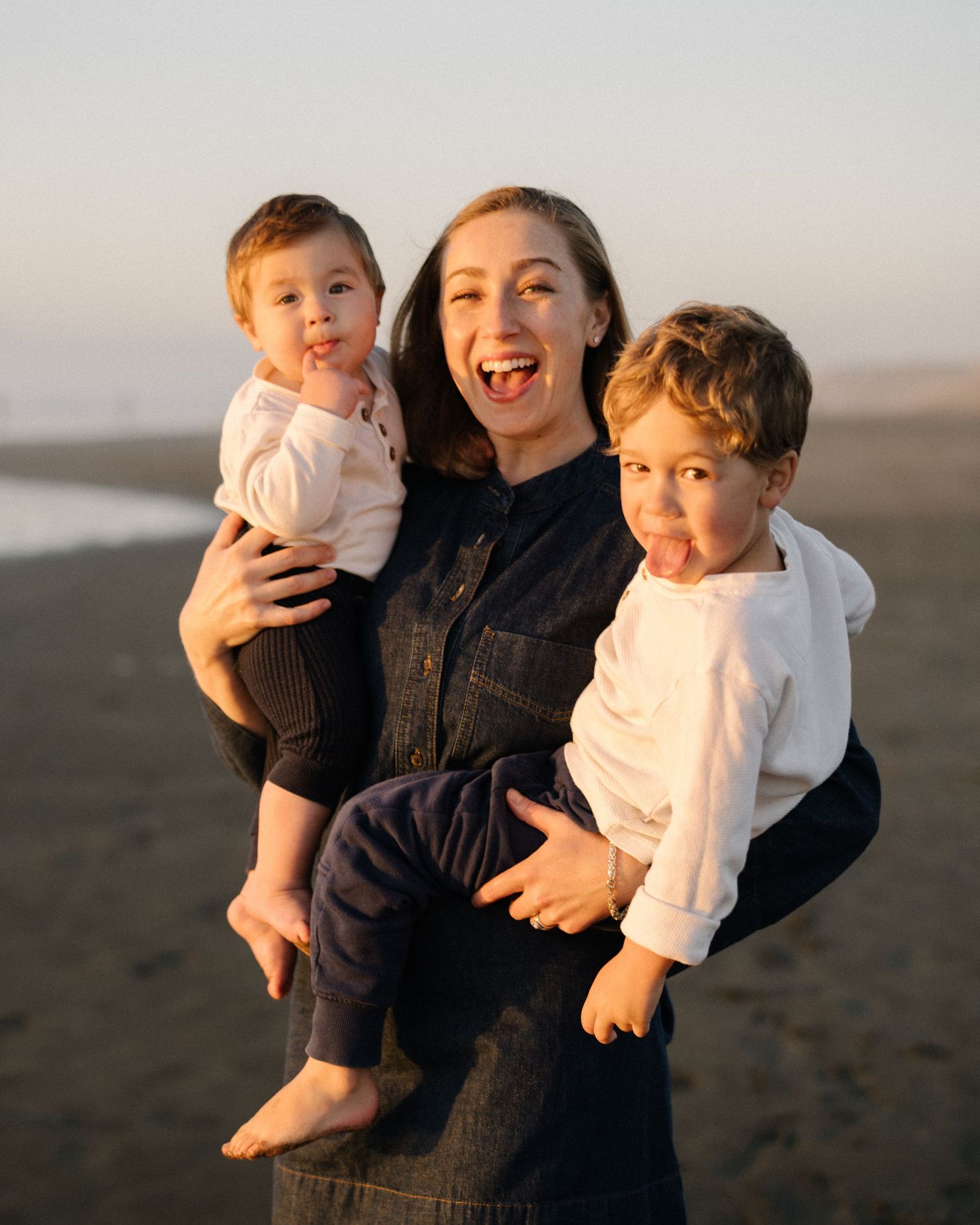 A family shares joyful moments together during sunset at the beach.