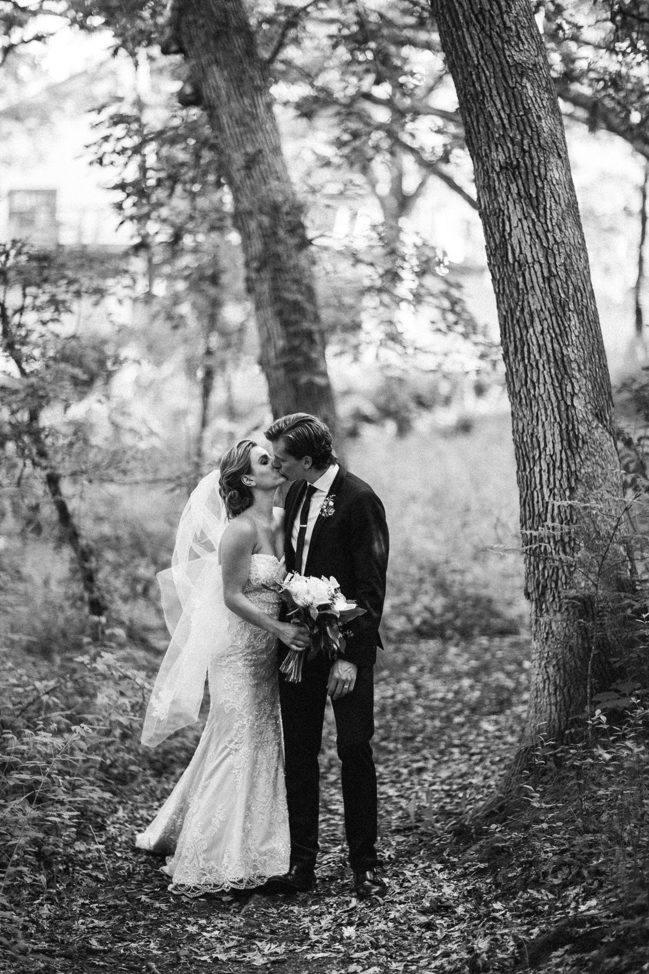 A sequence of romantic black and white wedding photos showing a couple in a wooded forest setting.