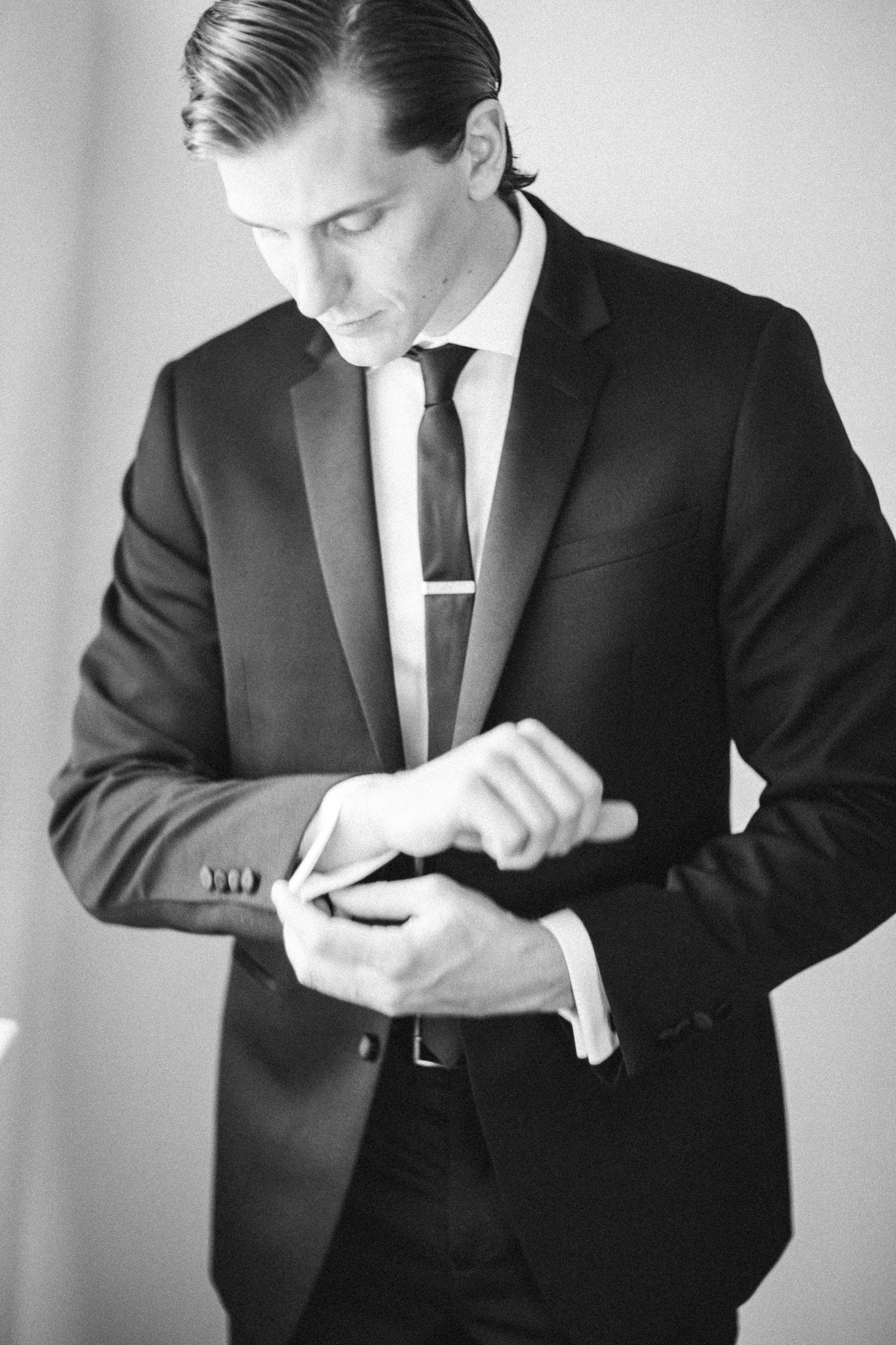 A sequence of black and white photos showing a groom checking his watch while getting ready.