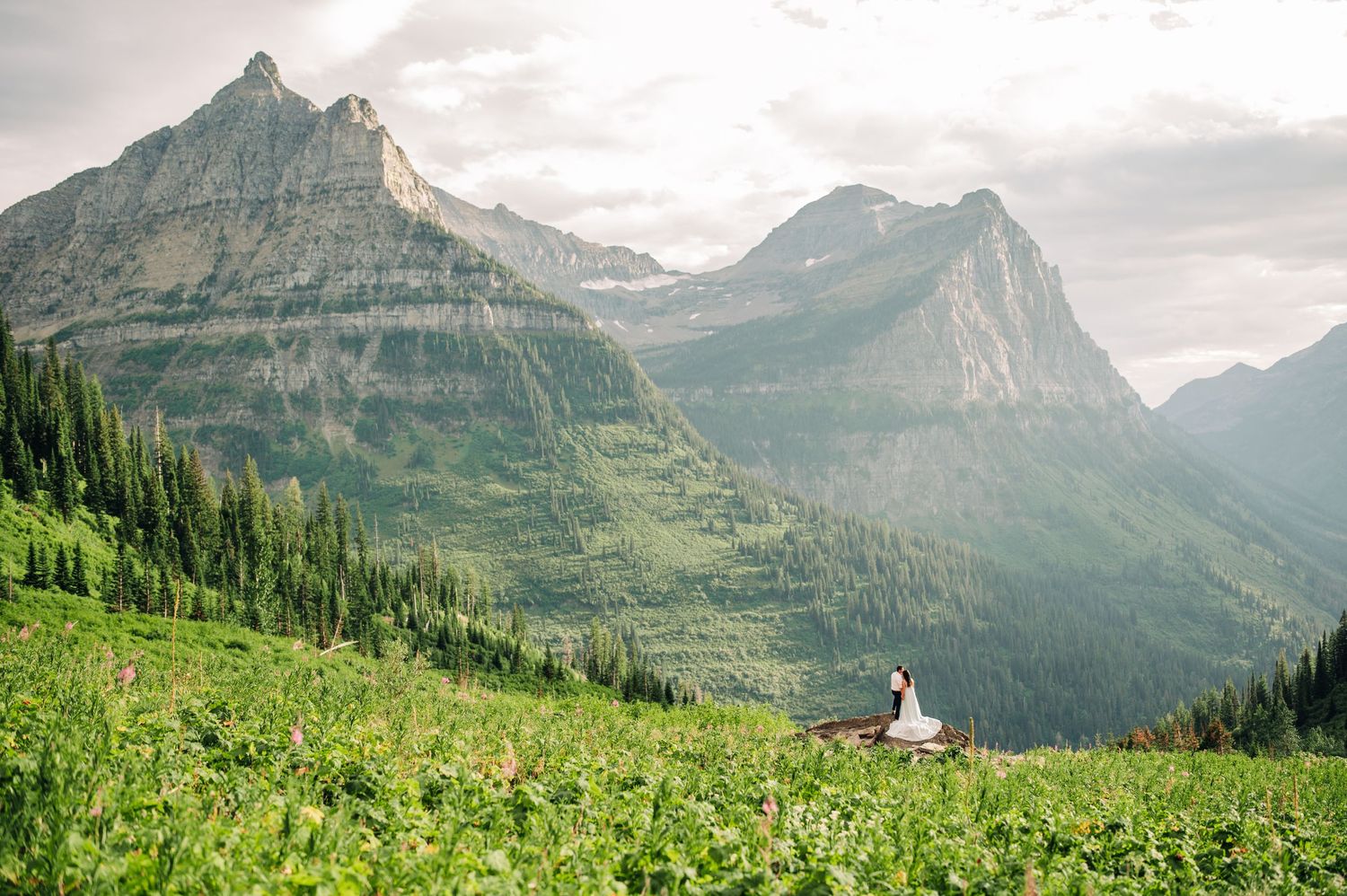 Dramatic mountain landscape with a small white chapel nestled among green alpine meadows.