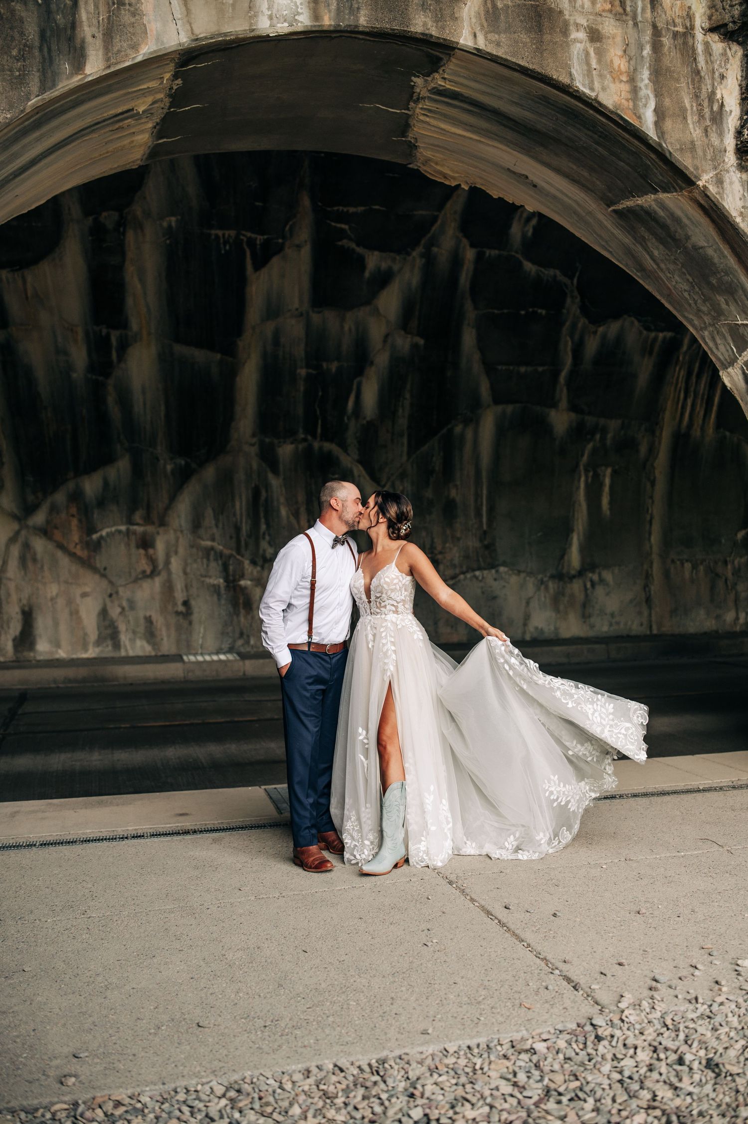 wedding couple standing in arch of tunnel in glacier national park