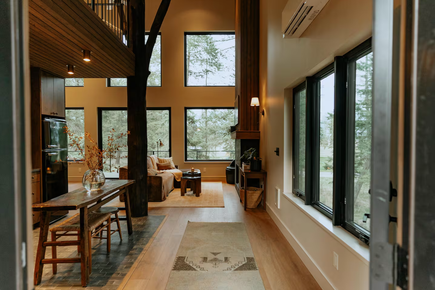 Modern open concept home interior with large windows and cathedral ceilings showcases contemporary architectural design.