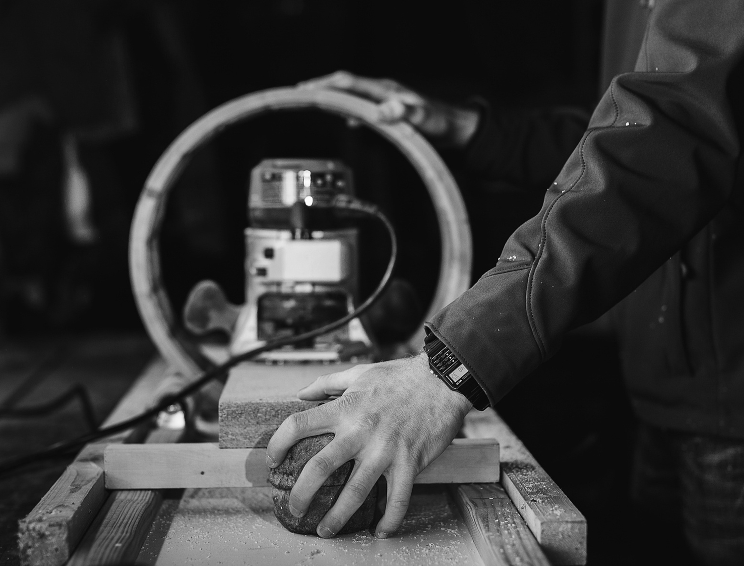 Professional coffee roaster checking beans in production facility with testing equipment and monitoring display.