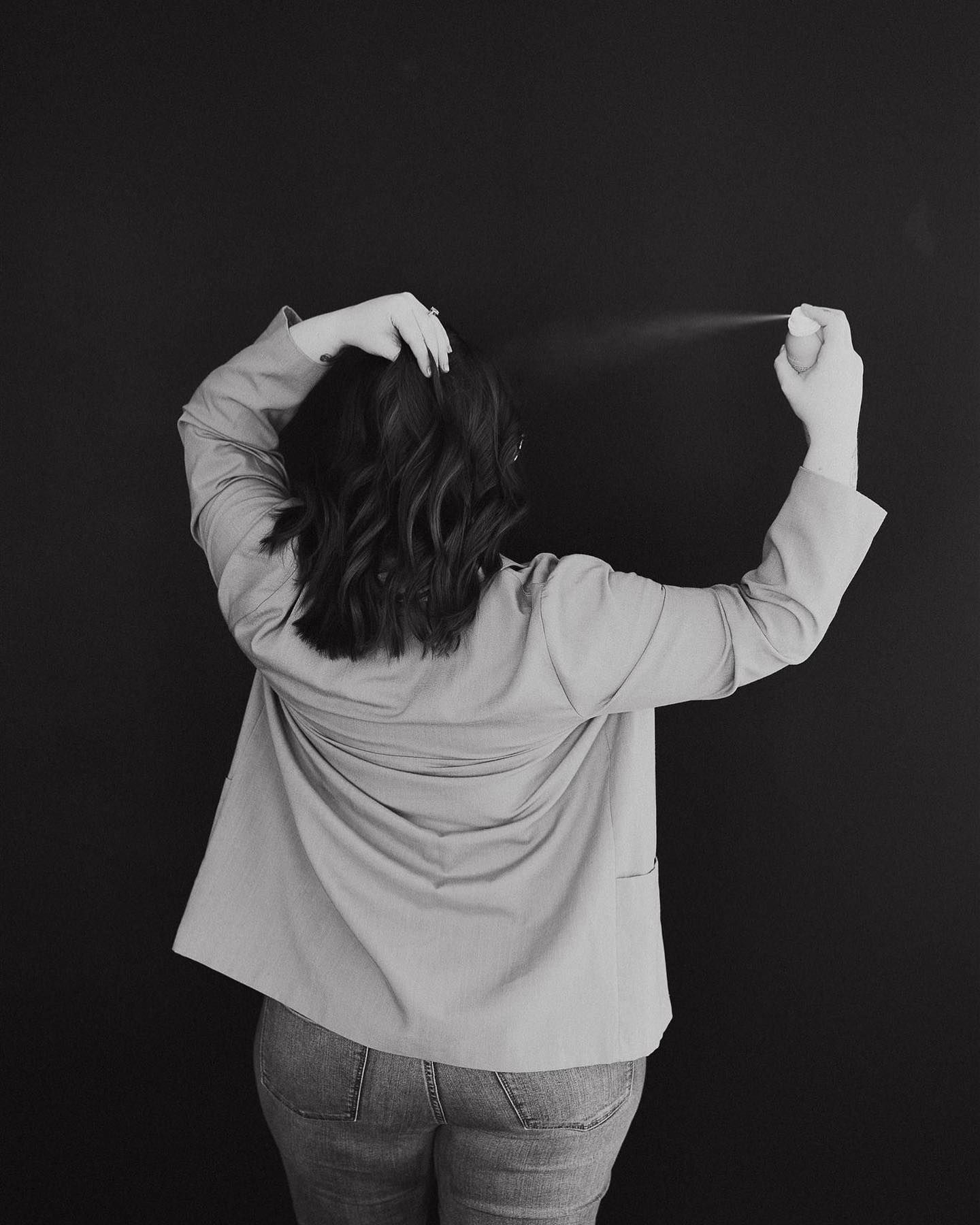 Black and white artistic photo showing back view of person in light colored jacket.