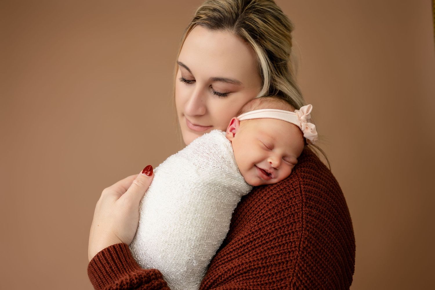 Tender moment in warm tones with cozy knit sweater and soft wrap.