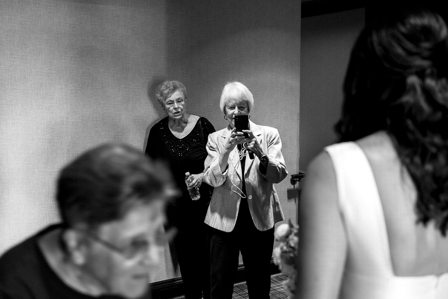 A series of black and white candid photos arranged in a horizontal strip showing various people in conversation.