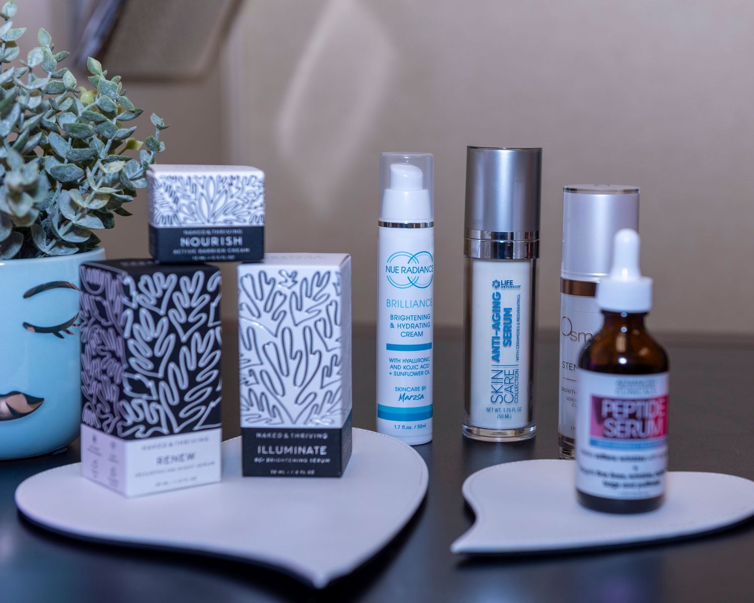A curated skincare collection featuring Nourish, Illuminate, Neogen, and Peptide Serum products displayed on a tray.