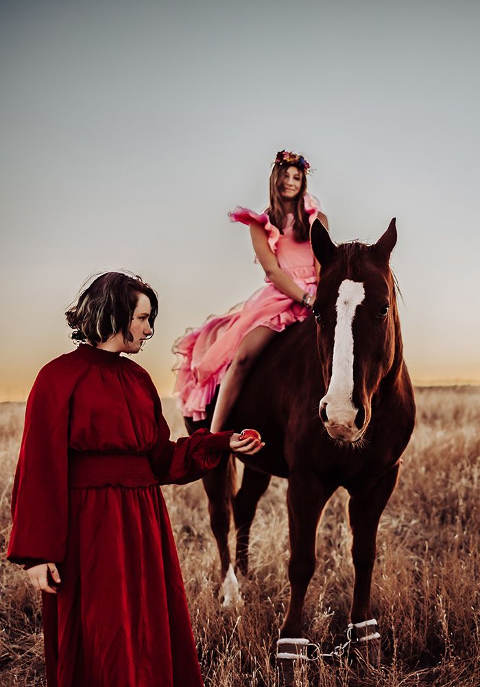 girl feeding horse with rider
