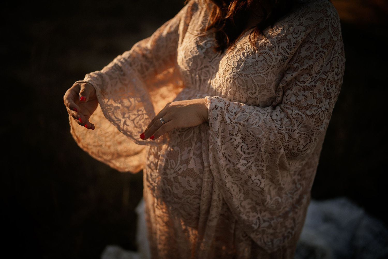 Sunlit lace detail of wedding dress fabric in warm tones.
