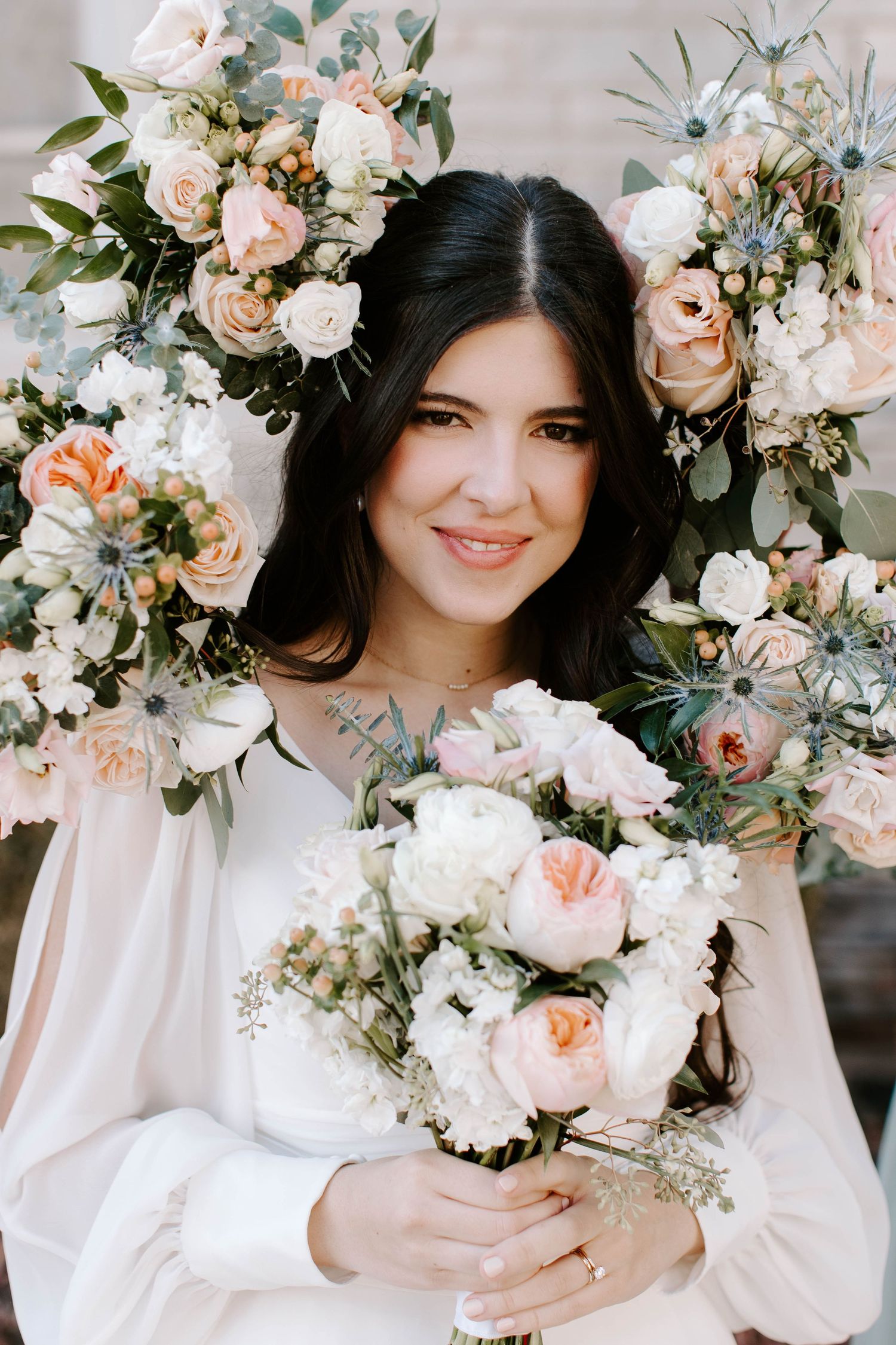 Bridesmaid's bouquets make a halo around this gorgeous bride's face, showing off her natural soft-glam makeup look.