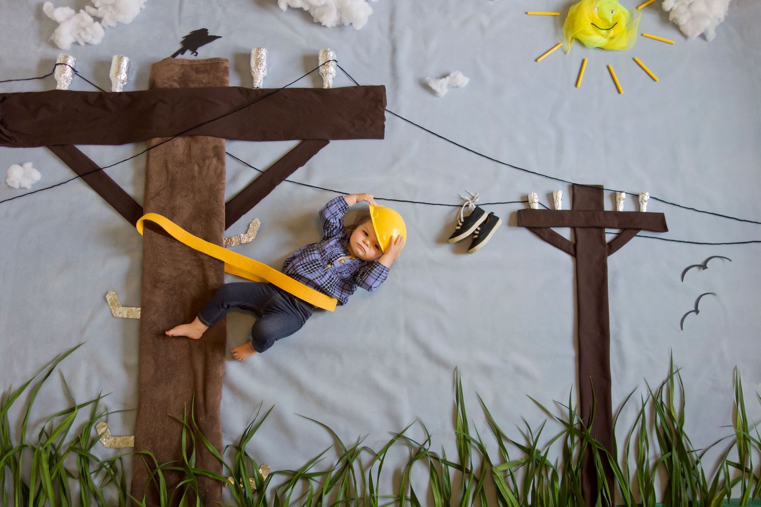 Creative scene of toy figure climbing utility pole against painted sky background.
