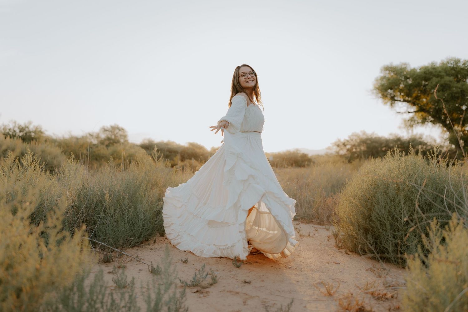 Ethereal portrait session featuring flowing white dress against desert backdrop.