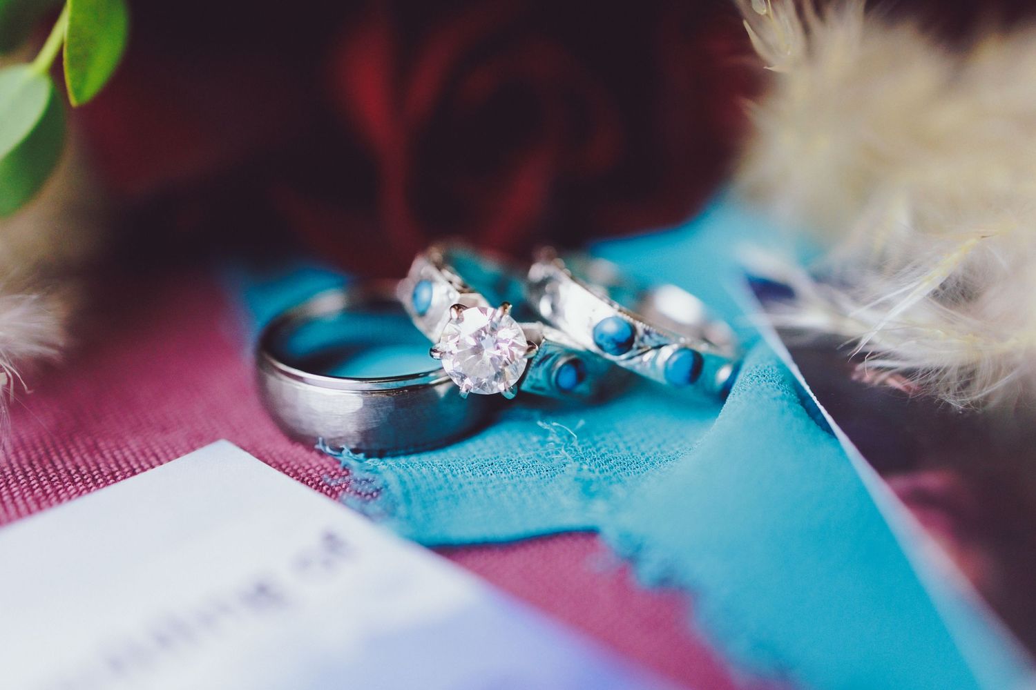 three wedding rings on a blue cloth sitting on a table.