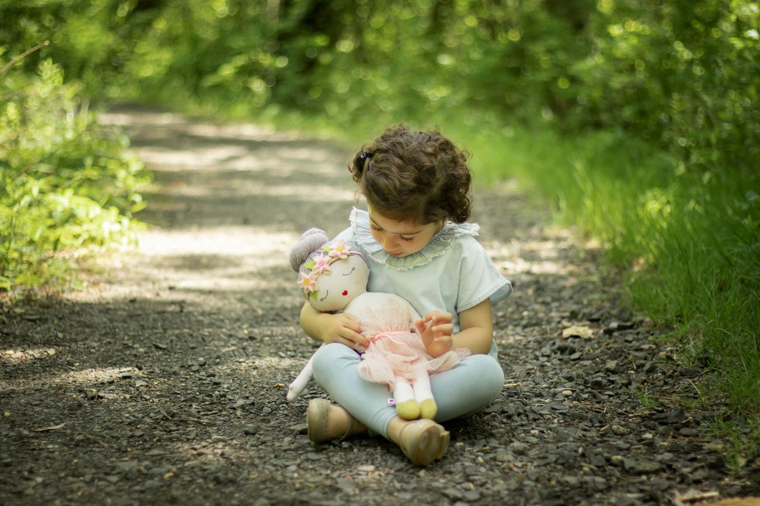 Toddler girl looking on fondly at her vintage doll