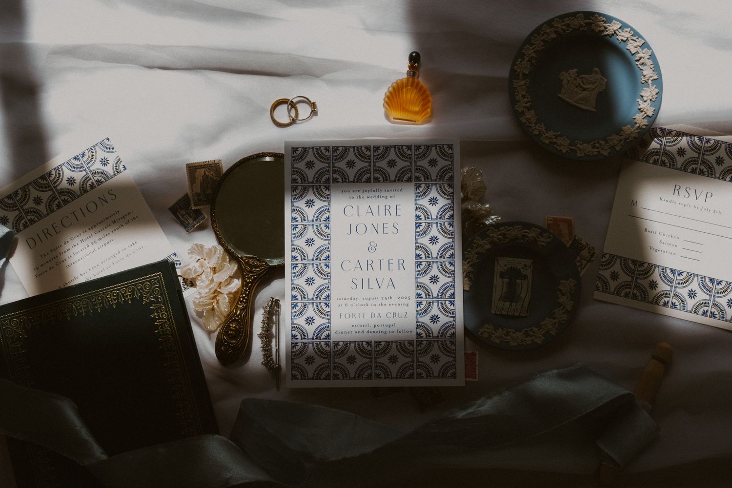 Wedding details flat lay with rings, invitation and decorative elements.