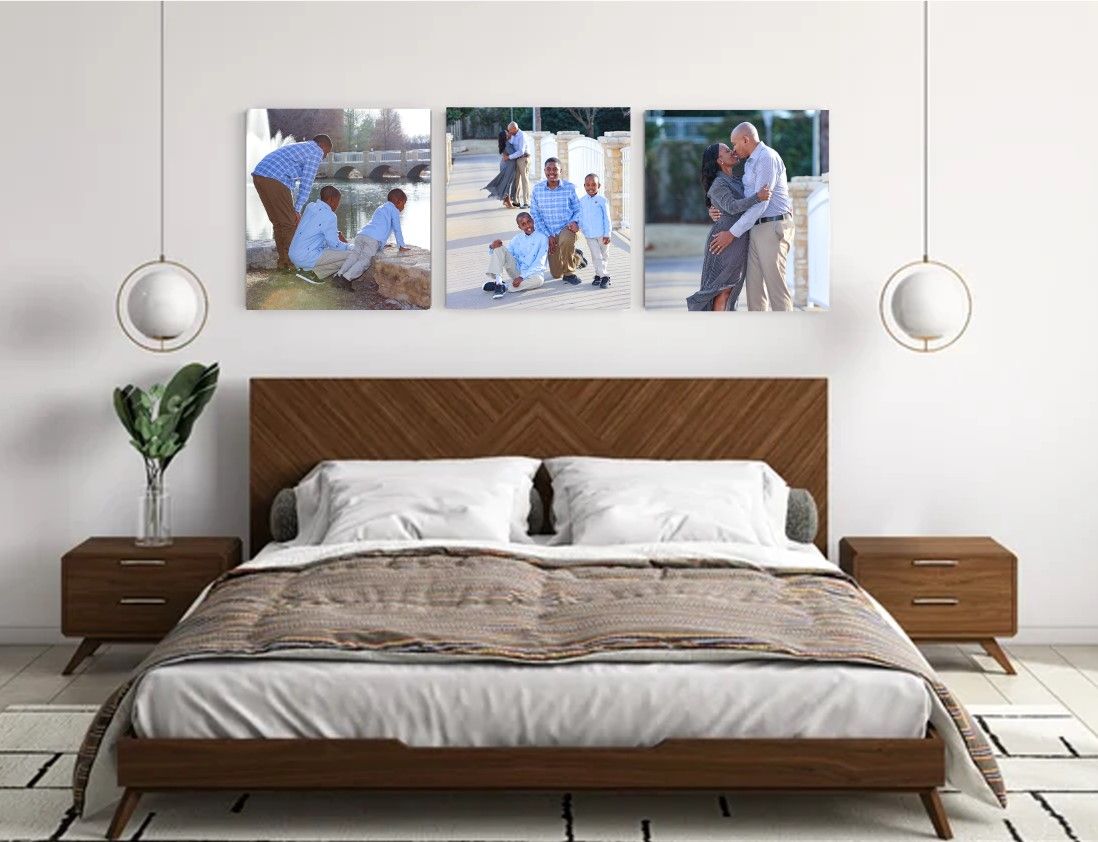 Modern bedroom interior with wooden bed frame, white bedding, and family photos displayed above the headboard.