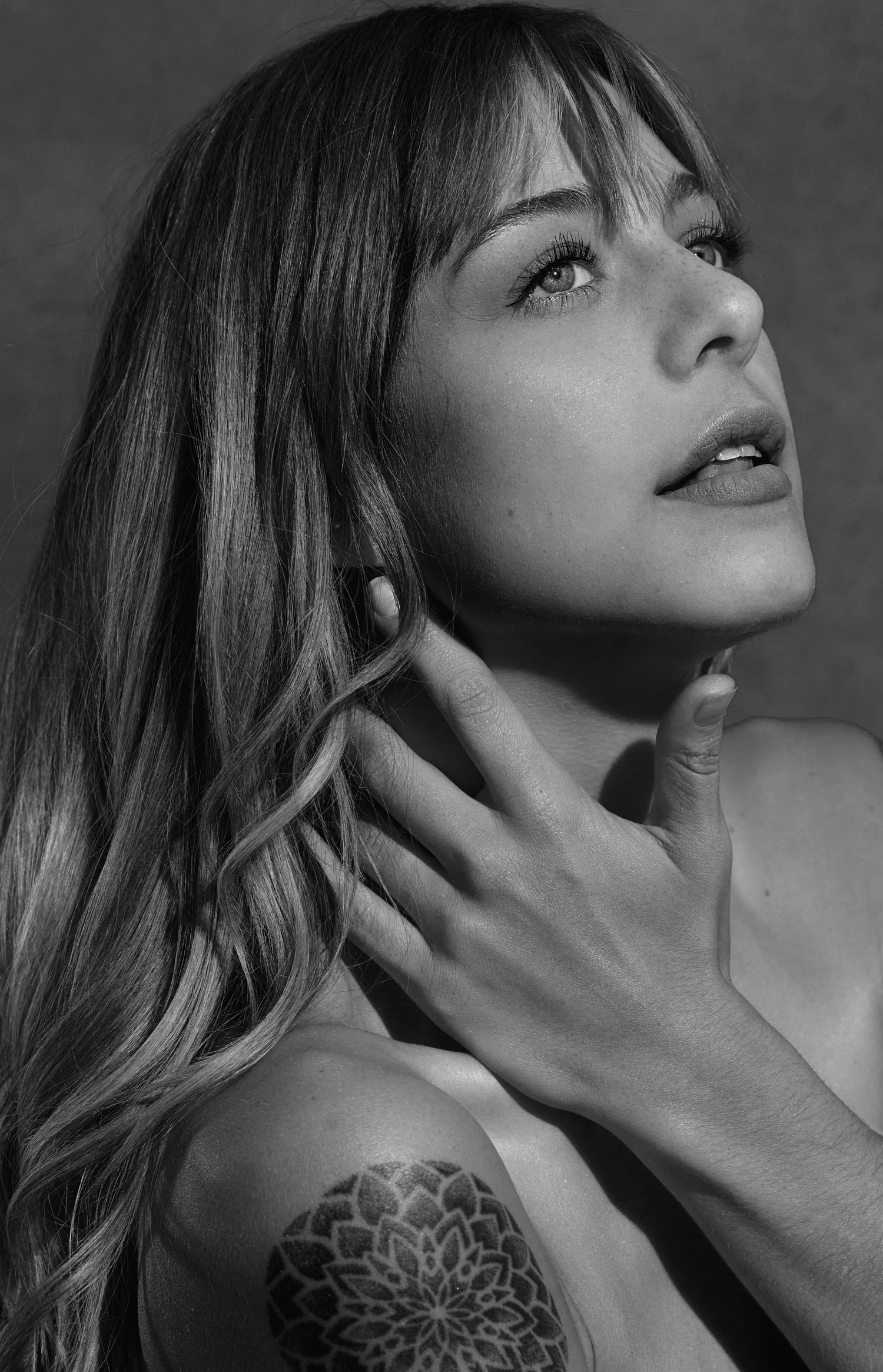 Artistic black and white portrait highlighting delicate hand gesture.