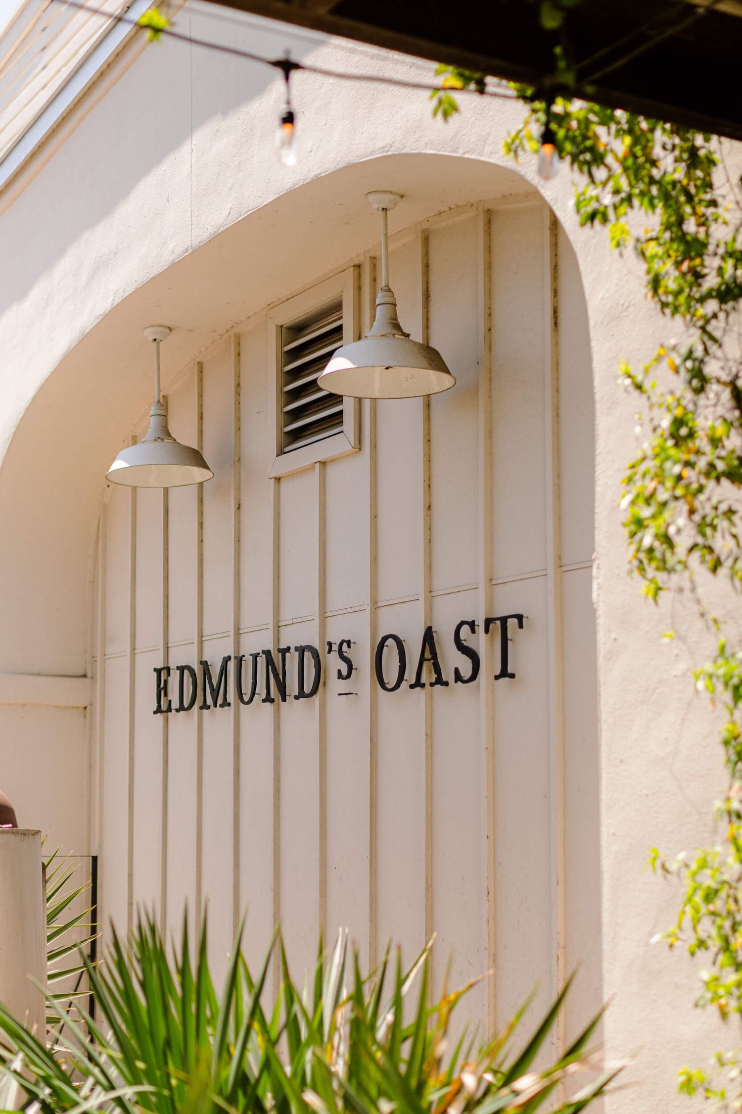 Edmund's Oast restaurant exterior sign with vintage pendant lights and white architectural details.