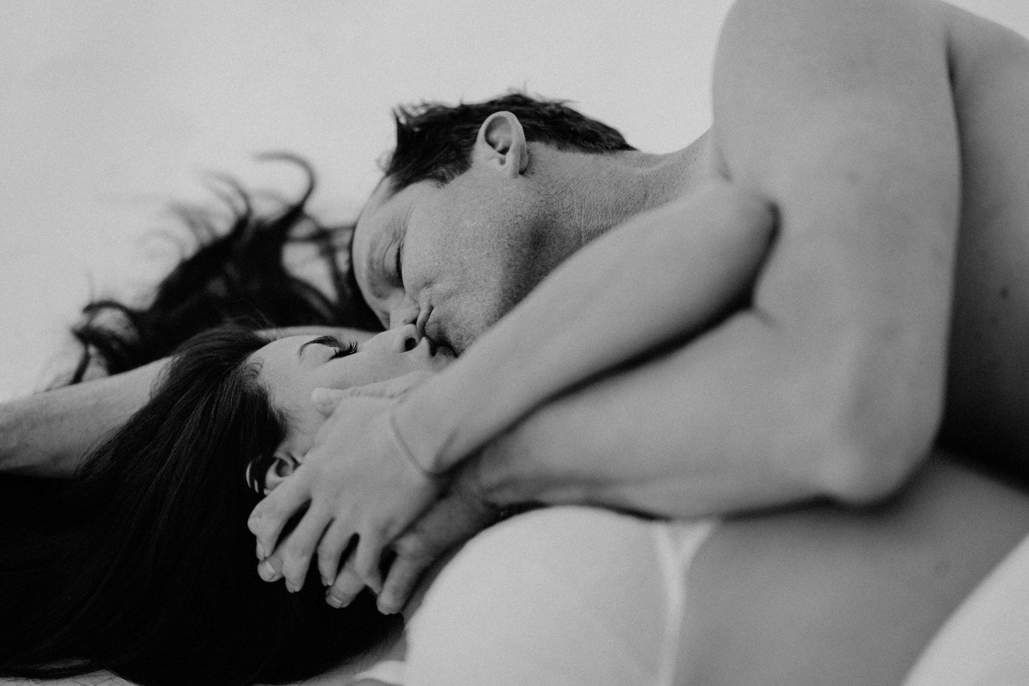 Intimate black and white portrait of couple sharing tender moment.