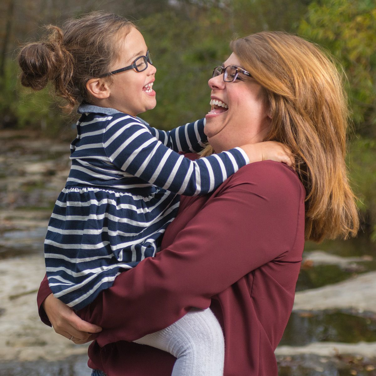 A mother holding her daughter, laughing together on an autumn afternoon — a timeless family photo in Fulton, MO.
