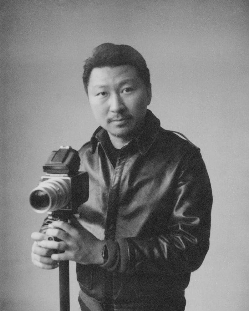 Black and white photo series showing person holding and posing with a camera in various angles.