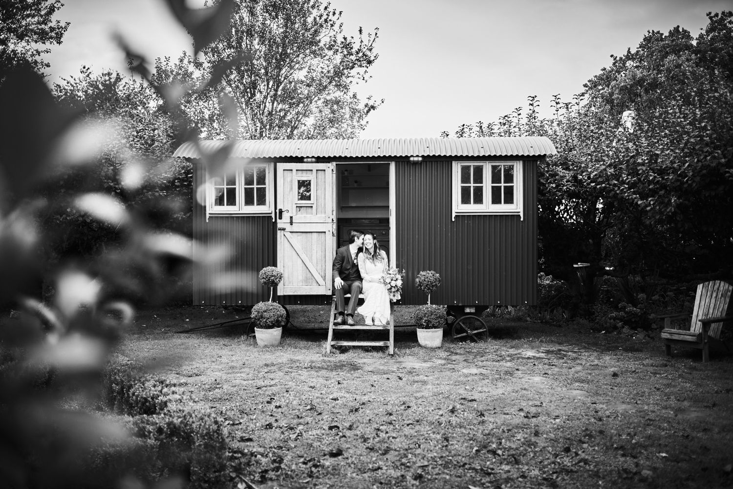 Monochrome image of rustic shepherd's hut with steps in countryside.