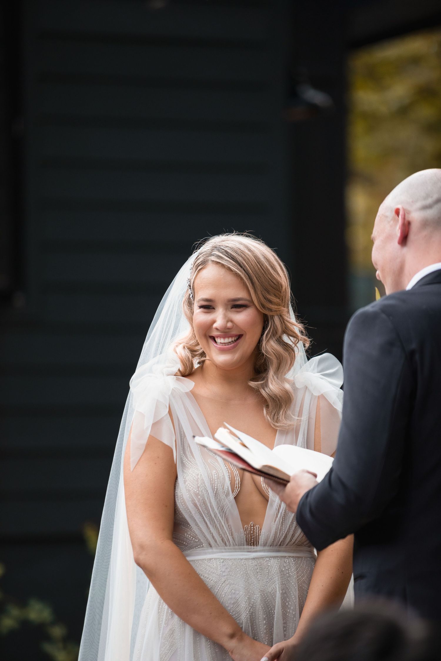 Wedding day portrait of the bride laughing at her husband's speech.