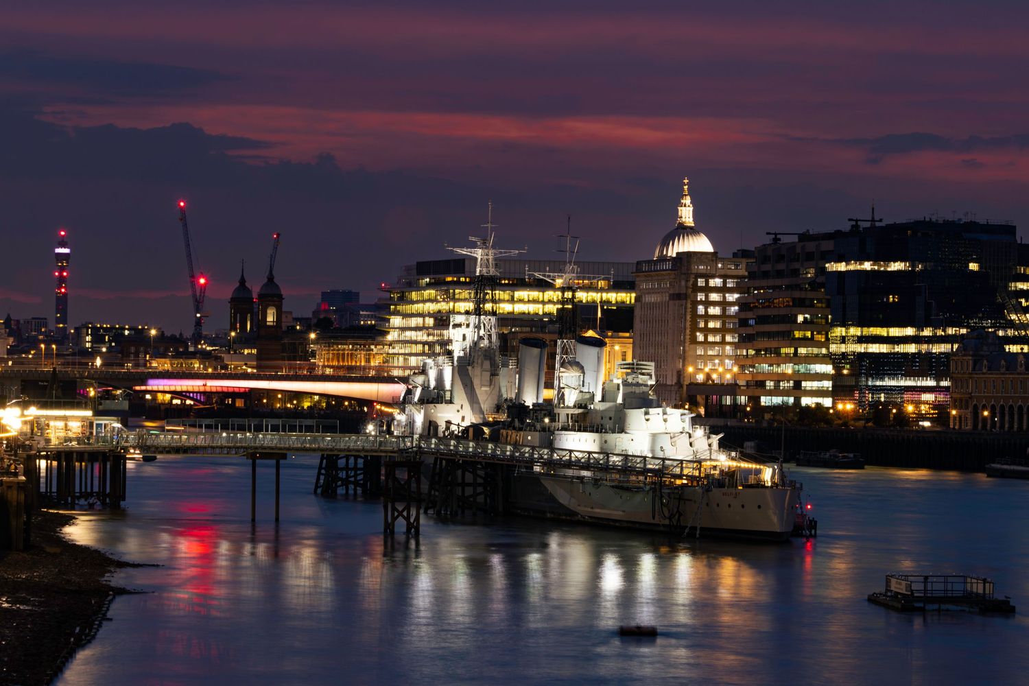 HMS Belfast, The BT Tower, London Bridge and St. Paul's Cathedral at low tide on the River Thames captured by Kush Ratta