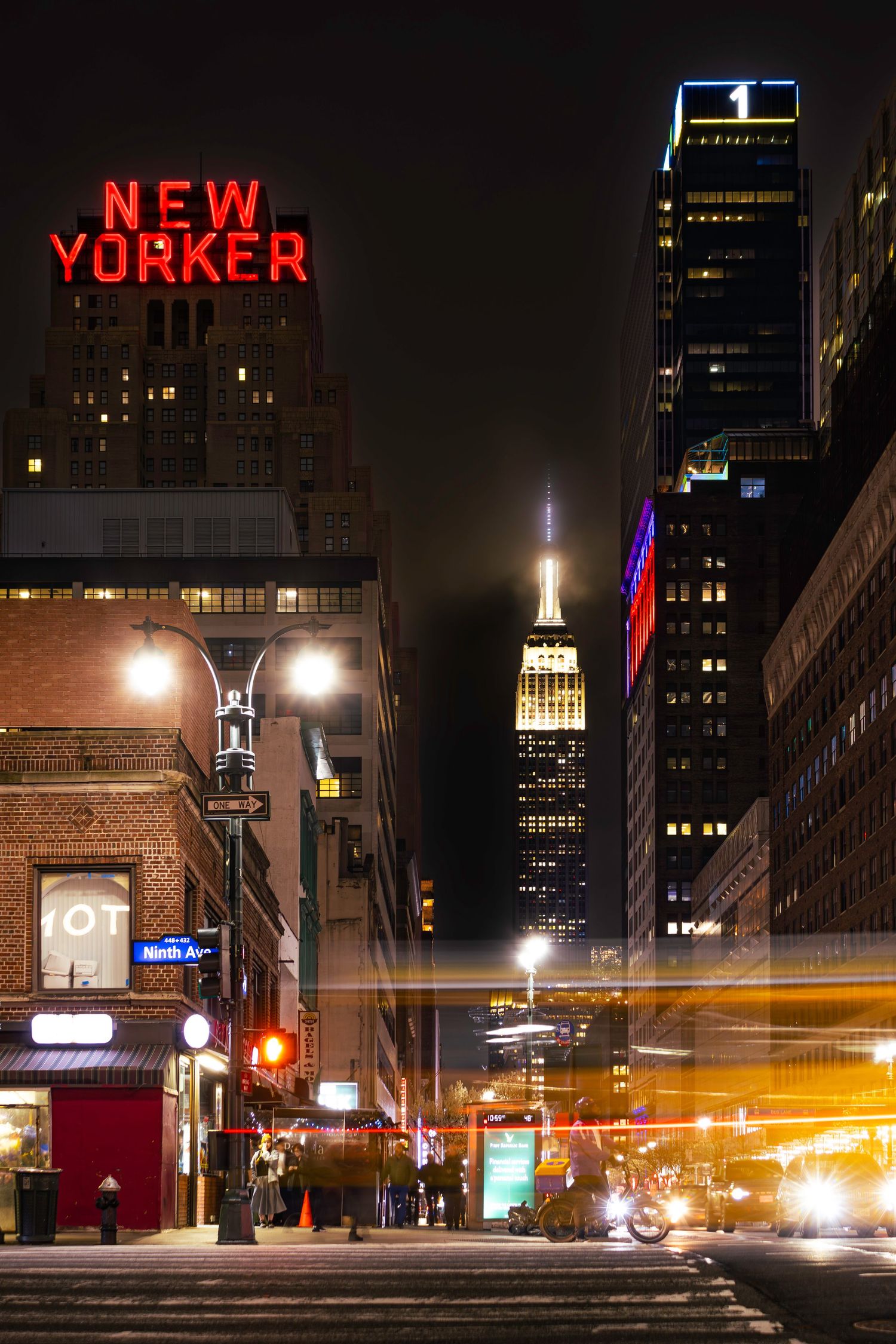 The Empire State Building and New Yorker hotel with a yellow taxi light trail in Manhattan York by Kush Rattan Photograp