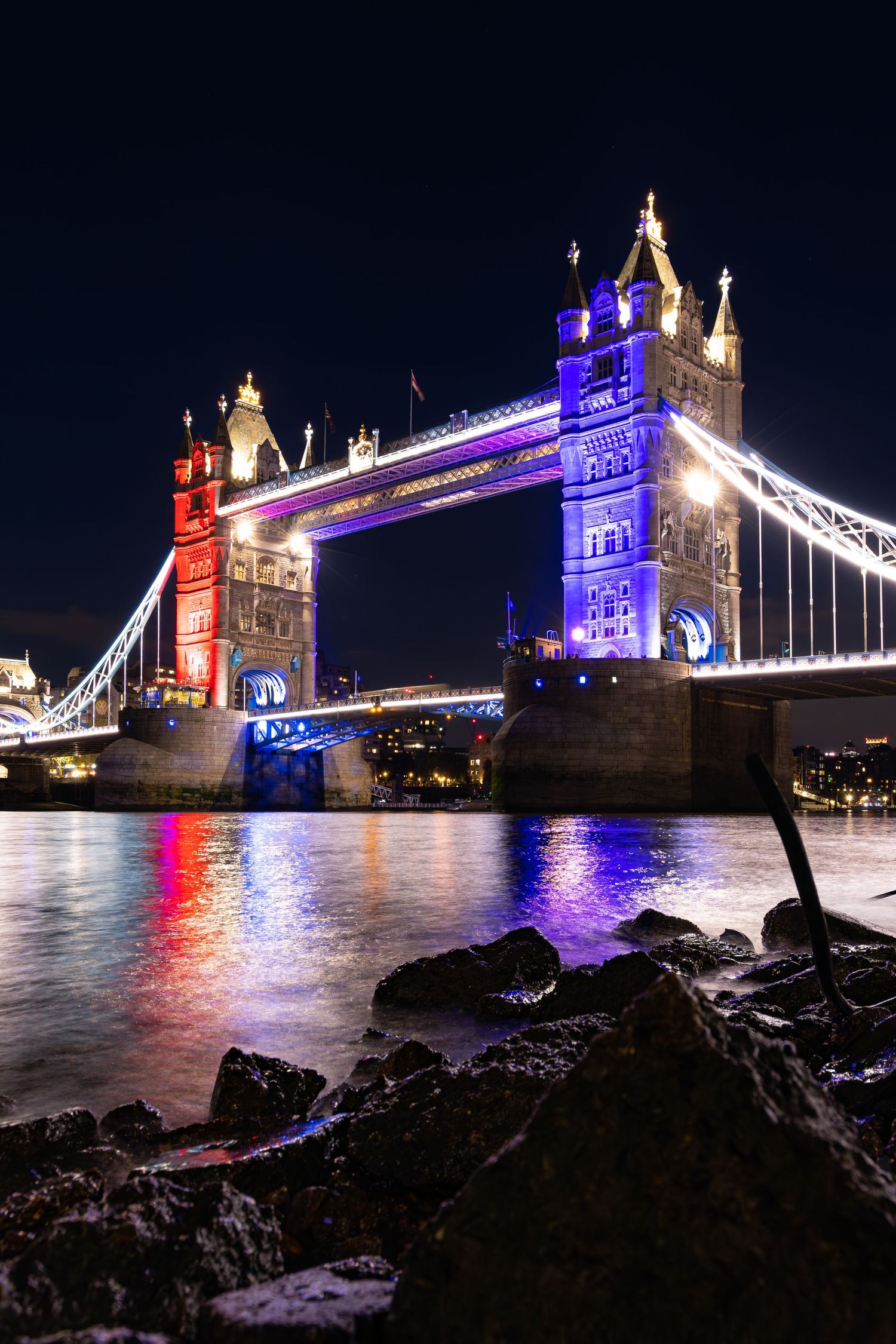 Tower Bridge all lit up in red white and blue for King Charles III coronation river Thames by Kush Rattan Photography at