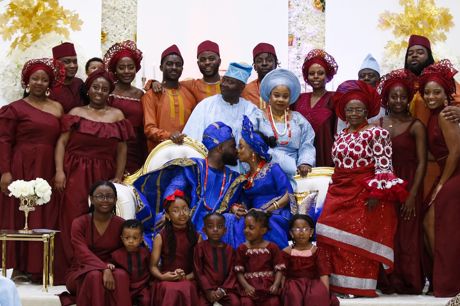 Wedding party members in coordinating burgundy and blue attire posing together for formal group photos.