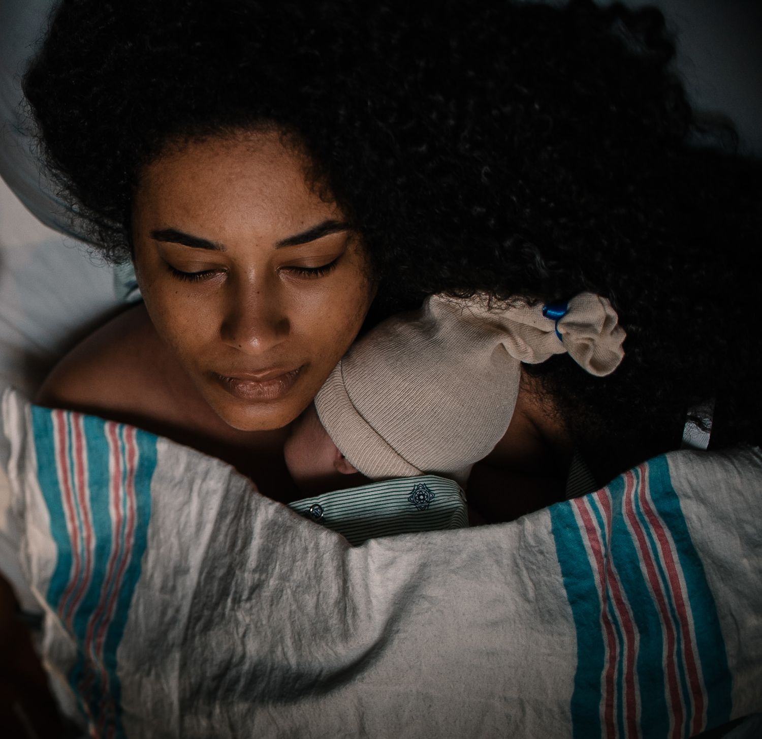 Mother Holding Baby Skin to Skin Under A Hospital Blanket