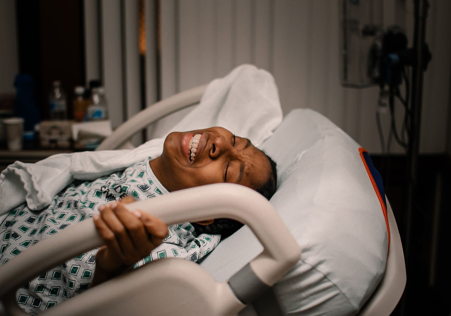 Black Woman Having A Contraction Laboring In Hospital Bed Holding Bed Rail