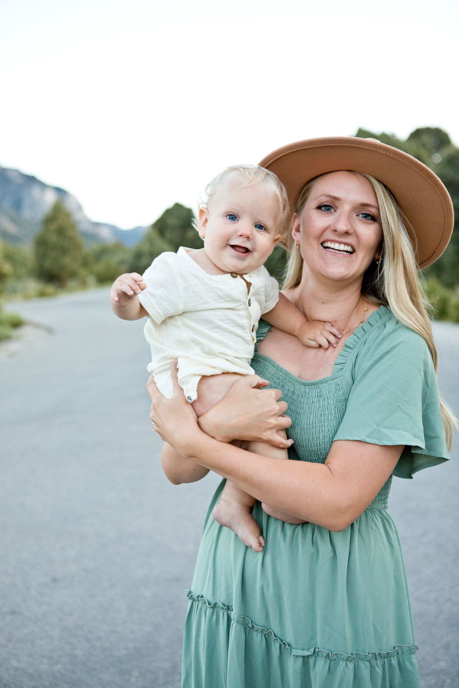 A sunny outdoor portrait with mountains in the background.