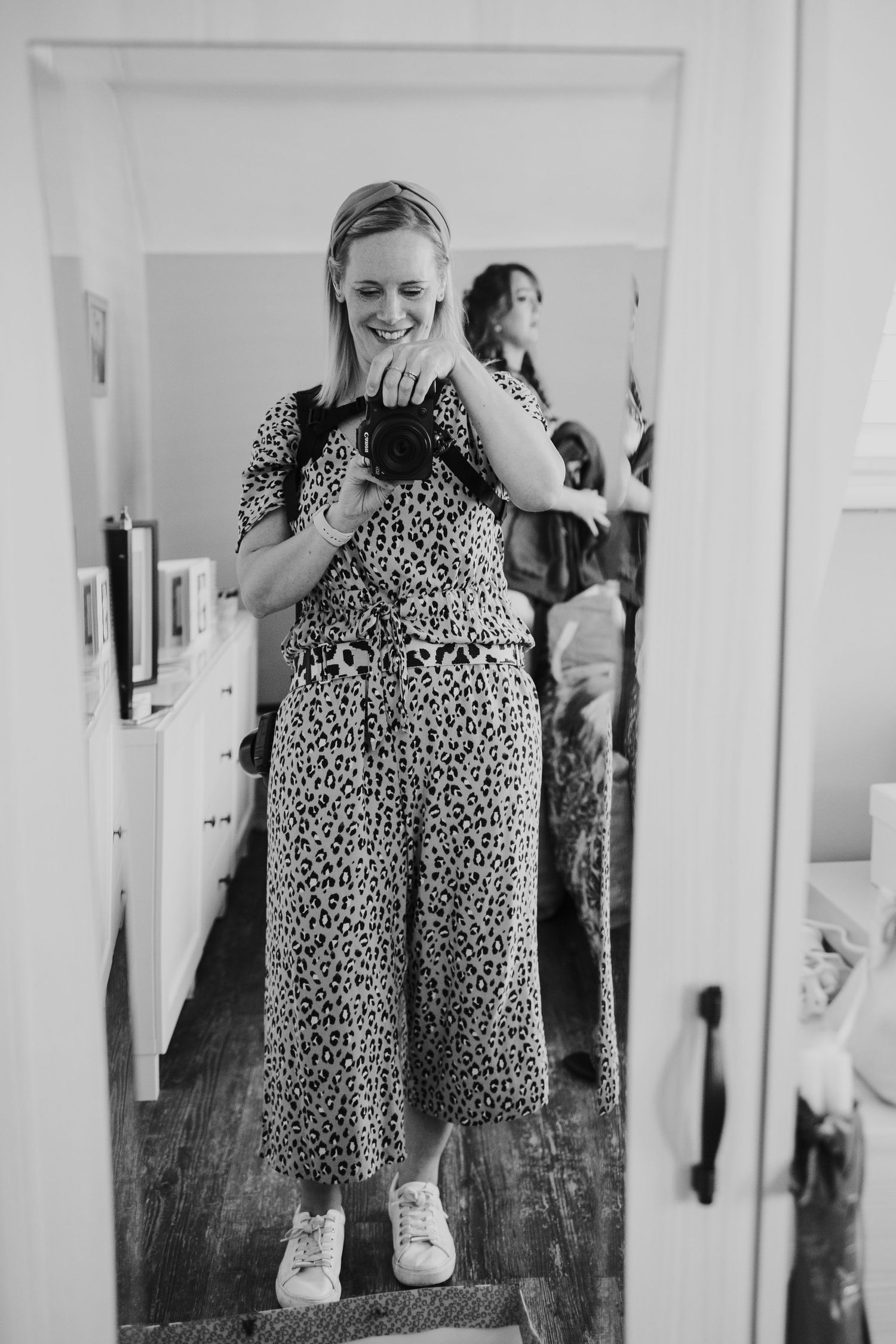 Mirror selfie of someone wearing a leopard print jumpsuit in black and white.
